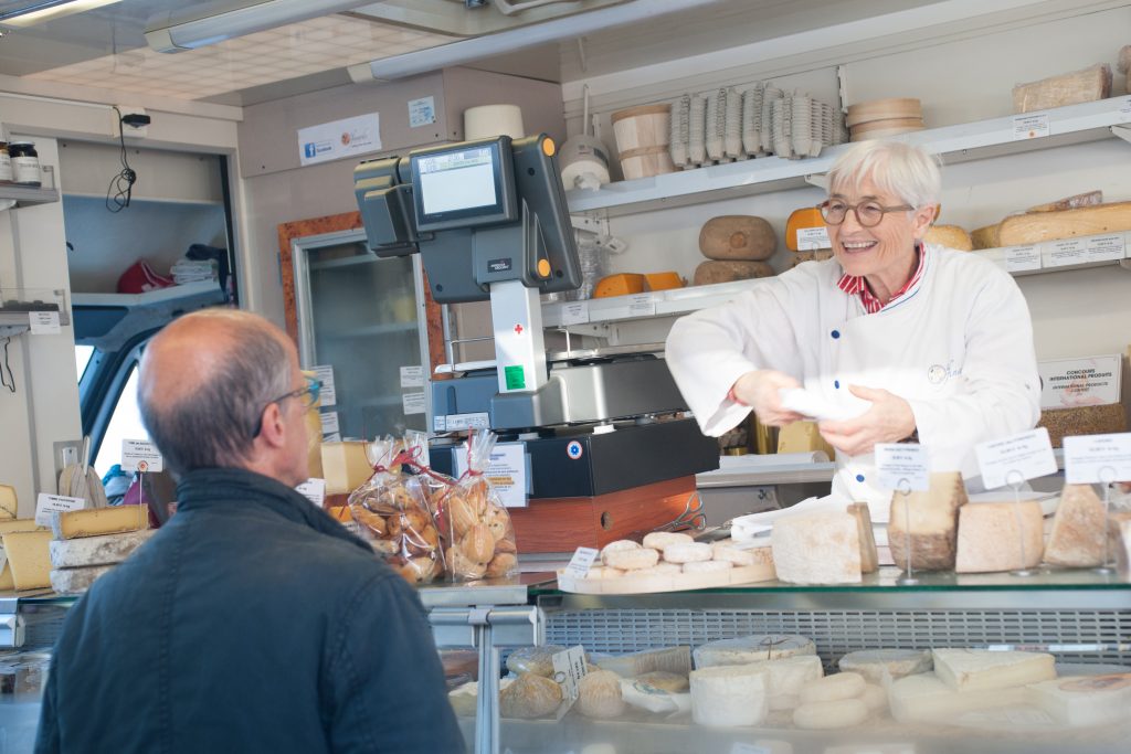 Cheese monger in her van at a market in Pas-de-Calais